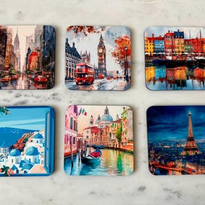 May include: Set of six square coasters featuring watercolor cityscapes. Images include New York City, London with Big Ben and a red double-decker bus, colorful buildings, a Greek island scene, Venice, and the Eiffel Tower.