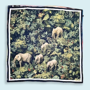 May include: A square, dark green and black patterned silk scarf with a white border features a design of five elephants in a jungle setting. The elephants are light brown and are walking through a lush green forest with red berries.