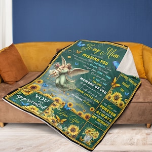 Puede incluir: Una manta verde y amarilla con un diseño de girasol y mariposa. La manta presenta una cita sobre extrañar a una madre y una imagen de un ángel sosteniendo a un niño. El texto en la manta dice: "To my Mom Whenever I am Missing You I also remember how fortunate I was in my life The world changes from year to year Our lives from day to day but the love and memory of you shall never pass away I will always be your little girl and you will always be my loving Mom I'll love you forever I'll like you for as long as I'm living You'll always be my mommy You'll be"