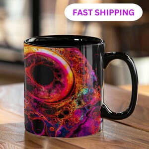 May include: Black coffee mug featuring a colourful abstract design in red, orange, yellow, and purple hues. The mug has a black interior and handle. The text "FAST SHIPPING" is in a white oval above the mug.