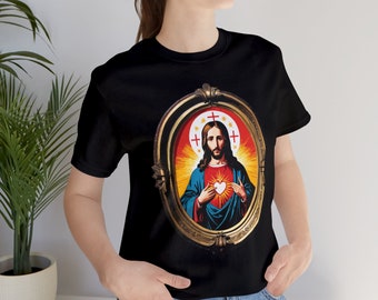 Könnte beinhalten: Schwarzes T-Shirt mit einem goldgerahmten Bild von Jesus Christus mit einem roten Herzen und einer Dornenkrone. Das Bild ist von einem roten und gelben Heiligenschein umgeben.
