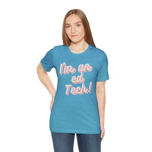 May include: A turquoise blue t-shirt with the text "I'm an ed Tech!" in pink and white lettering.