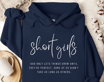 Pode incluir: Camisola de moletom azul marinho com capuz com o texto "short girls" em fonte branca cursiva. O texto abaixo diz "God only lets things grow until they're perfect, some of us didn't take as long as others."