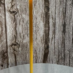 May include: A gold floor lamp with a white cylindrical shade. The lamp is on a silver table.