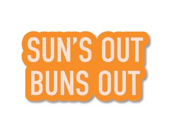 May include: A die-cut sticker with an orange background and the text SUN'S OUT BUNS OUT printed in a light cream color. The sticker features a bold, rounded rectangular shape that follows the contour of the two lines of text.