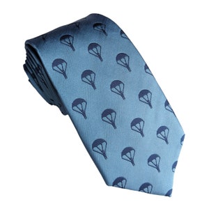 May include: A light blue silk tie with a repeating pattern of dark blue parachutes.