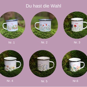 May include: Six enamel mugs with different floral designs. Each mug has a white background with colorful flowers and a black rim. The mugs are arranged in a grid of two rows and three columns. The text "Du hast die Wahl" is at the top of the image.