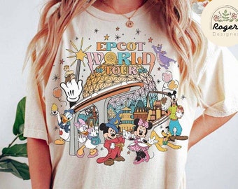 Könnte beinhalten: Ein beiges T-Shirt mit einem bunten Grafikdruck von Mickey Mouse und seinen Freunden auf der Epcot World Tour. Die Grafik enthält den Text "Epcot World Tour" und zeigt ein Cartoon-Bild der Epcot-Kugel.