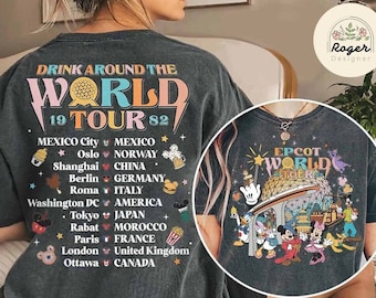 May include: A black t-shirt with a colorful graphic design featuring the text "Drink Around the World 19 Tour 82" and a list of cities and countries. The graphic also includes a cartoon image of a globe with a Mickey Mouse head on top. The back of the shirt features a colorful graphic design with the text "EPCOT World Tours" and a cartoon image of the EPCOT World Showcase Lagoon with Mickey Mouse and other Disney characters.