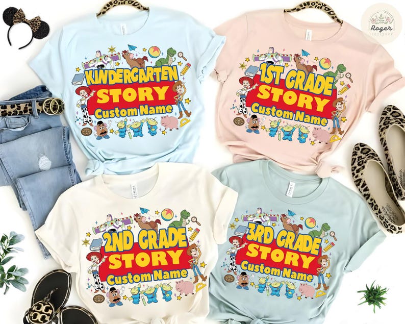 Pu&ograve; includere: Quattro magliette a maniche corte con grafiche colorate. Ogni maglietta presenta il testo "Kindergarten Story", "1st Grade Story", "2nd Grade Story" e "3rd Grade Story" con "Custom Name" sotto. Le magliette sono azzurro, rosa, bianche e verde chiaro.
