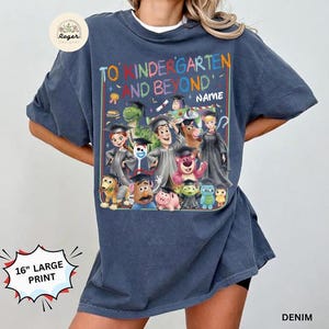 Peut inclure: T-shirt bleu denim avec un grand graphisme color&eacute; repr&eacute;sentant des personnages de la franchise Toy Story, dont Woody, Buzz l'&Eacute;clair et d'autres, avec le texte "TO KINDERGARTEN AND BEYOND". L'impression mesure 40.6 cm.