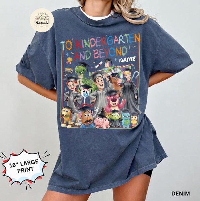 Peut inclure: T-shirt bleu denim avec un grand graphisme color&eacute; repr&eacute;sentant des personnages de la franchise Toy Story, dont Woody, Buzz l'&Eacute;clair et d'autres, avec le texte "TO KINDERGARTEN AND BEYOND". L'impression mesure 40.6 cm.