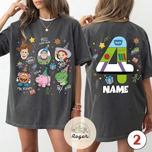 Puede incluir: Camiseta gris oscuro con personajes de Toy Story. La parte delantera muestra a Woody, Buzz Lightyear, Jessie, Sr. Potato, Ham y Rex. La parte trasera tiene un gran n&uacute;mero 4 y la palabra "NAME".