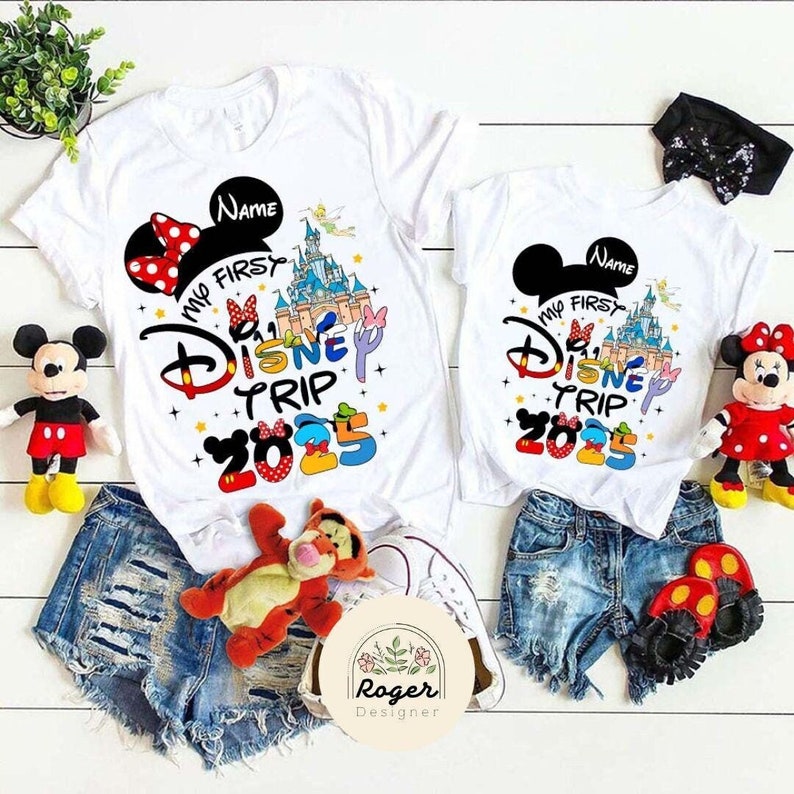 May include: White t-shirts featuring a Mickey Mouse design and the text "My First Disney Trip 2025".