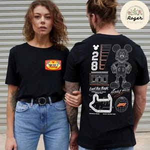 May include: Black t-shirts with Mickey Mouse graphics. One shirt features a patch with "Mickey Racing" text, the other has a wireframe Mickey Mouse and "Fuel the Magic" text. Both shirts have the number "28".
