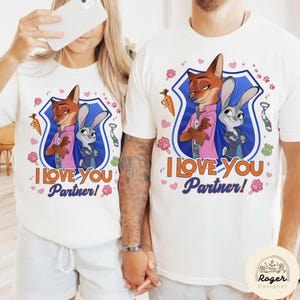 Pu&ograve; includere: T-shirt bianche con un design a cartoni animati di volpe e coniglio e la scritta "I Love You Partner!". Il design include uno scudo blu, carote, impronte di zampe e cravatte. Le magliette sono probabilmente abbigliamento per coppie.