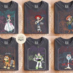 May include: A white ceramic mug with a black handle and the text "But First, Coffee" in a bold, black font. The mug is filled with a dark liquid, likely coffee, and rests on a light-coloured surface.