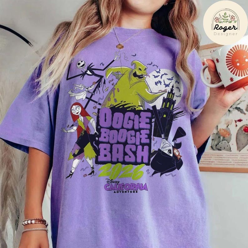 May include: A light purple t-shirt featuring a graphic print of characters from The Nightmare Before Christmas, including Oogie Boogie, Sally, and Jack Skellington. The text reads Oogie Boogie Bash 2026 Disney California Adventure.