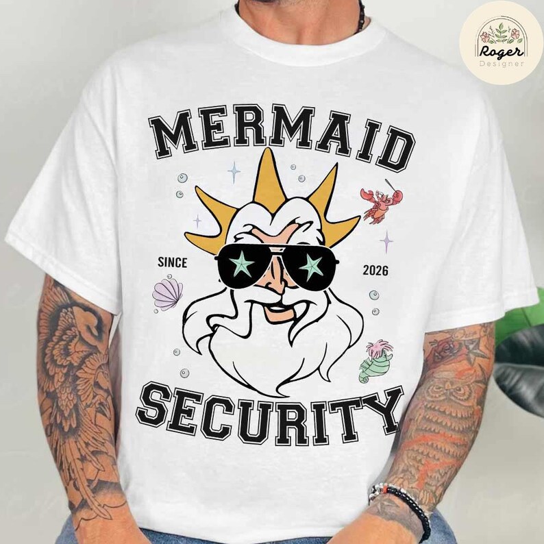 May include: White t-shirt featuring a cartoon illustration of a sea god wearing sunglasses with star-shaped lenses. The shirt has the words "MERMAID SECURITY" and "SINCE 2026" printed on it, along with other sea-themed graphics.