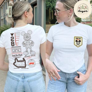 May include: White t-shirt with a Mickey Mouse graphic on the back and a small emblem on the front. The back graphic includes the number 28, a Mickey Mouse outline, and the text "Fuel the Magic". The front emblem says "Fuel the Magic".