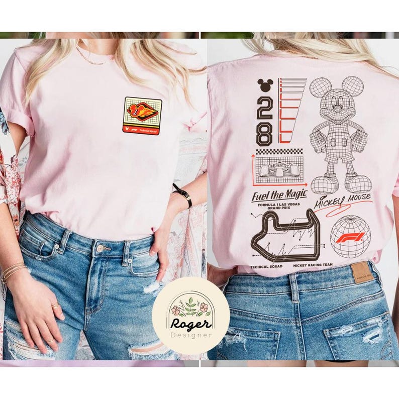 May include: A light pink t-shirt with a Formula 1 racing theme. The front features a small patch with a race car graphic. The back displays a Mickey Mouse outline, the number 28, and the text "Fuel the Magic" and "Mickey Mouse".