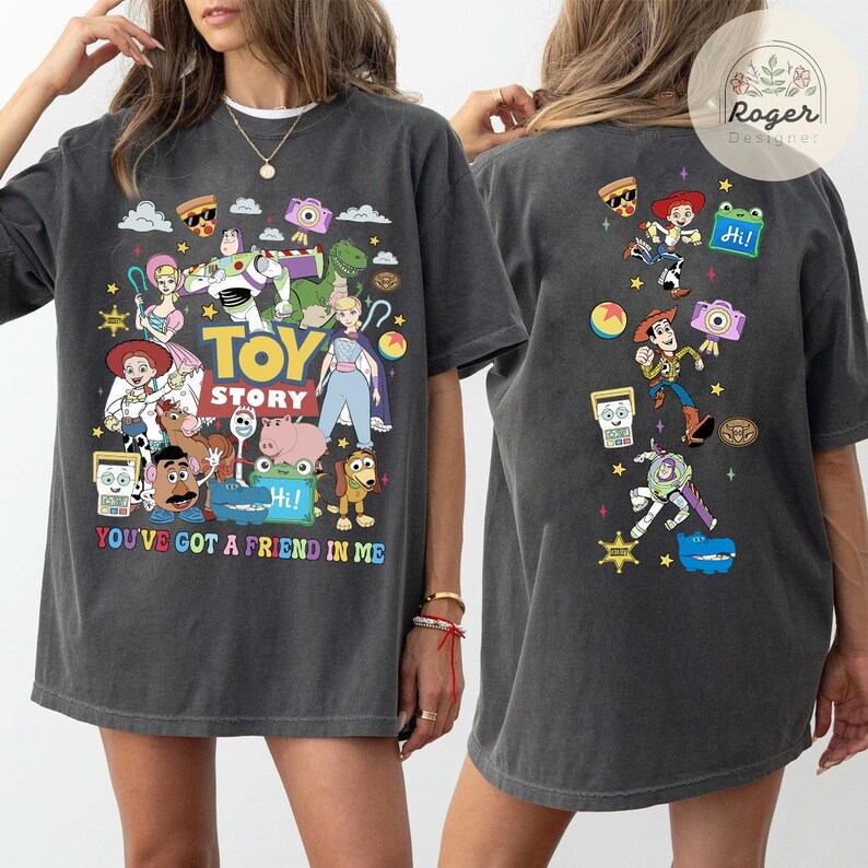May include: A charcoal gray t-shirt featuring Toy Story characters on the front and back. The front displays the Toy Story logo, the text 'YOU'VE GOT A FRIEND IN ME', and various characters. The back shows a vertical arrangement of characters.