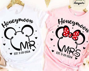 May include: Two white t-shirts with black Mickey Mouse ears and the words "Honeymoon" and "EST. 5-20-2024". One shirt says "MR" and the other says "MRS".