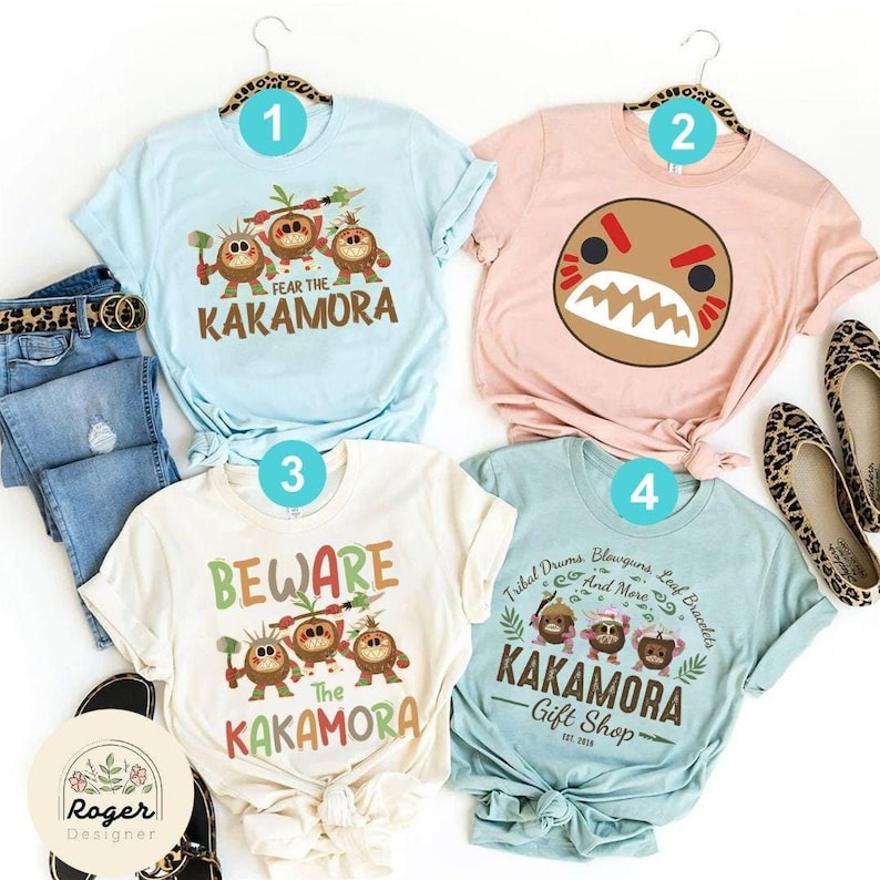 Puede incluir: Cuatro dise&ntilde;os de camisetas diferentes con los Kakamora de Moana. Las camisetas son azul claro, rosa, crema y turquesa. Los dise&ntilde;os incluyen el texto "Fear the Kakamora", "Beware the Kakamora" y "Tribal Drums, Blowguns, Leaf Bracelets and More - Kakamora Gift Shop".