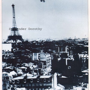 May include: A black and white photograph of the Eiffel Tower in Paris, France. A small airplane flies over the tower. The text "Swender Dorothy" is printed on the image.