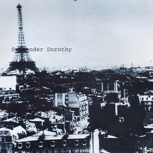 May include: A black and white photograph of the Eiffel Tower in Paris, France. A small airplane flies over the tower. The text "S.ender Dorothy" is printed on the image.