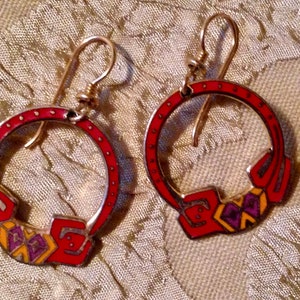 May include: A pair of red, yellow, and purple enamel earrings with a Celtic knot design.