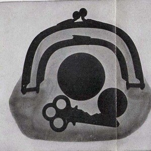May include: A black and white image of a vintage purse with a key and two circles inside. The purse has a metal clasp and is made of a soft material.