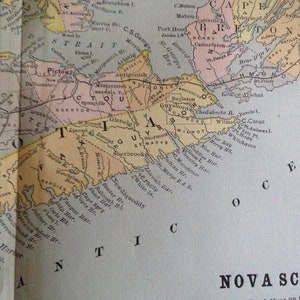 Op de afbeelding: Een vintage kaart van Nova Scotia, Canada, met de nadruk op het oostelijke deel van de provincie. De kaart is gedrukt in tinten bruin, geel, roze en groen, en bevat de namen van verschillende steden, dorpen en geografische kenmerken.