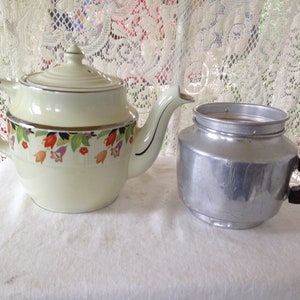 May include: A vintage yellow teapot with a floral design and a silver percolator with a brown handle.