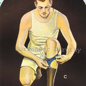 May include: A man is wearing a white tank top and is putting on a pair of black socks. He is sitting on a dark background. The socks have a blue band around the top.