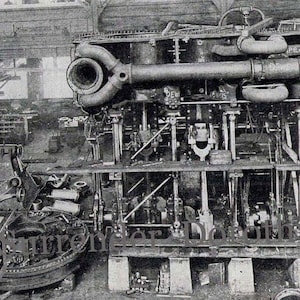 May include: A large industrial steam engine featuring complex metal piping, pistons, and mechanical linkages. The machinery is dark in color with visible bolts and structural supports. The text "Surrender Dorothy" is overlaid on the lower section.