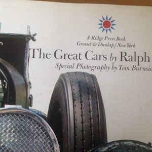 May include: A book cover featuring a black and silver classic car with a close-up of the tire. The title of the book is "The Great Cars by Ralph Stein" with the subtitle "Special Photography by Tom Burnside".