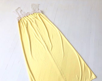 May include: A yellow maxi dress with white lace trim at the neckline and straps.