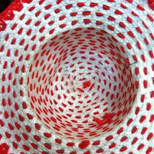 Puede incluir: Un sombrero de crochet blanco y rojo con una etiqueta que dice "Hecho en Taiw&aacute;n".