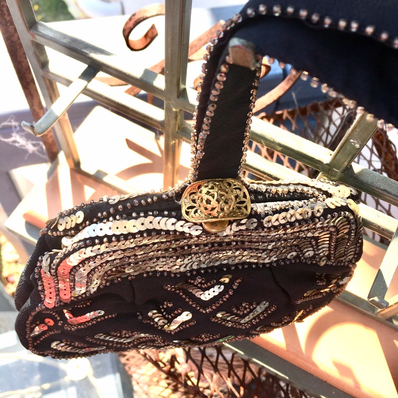 May include: A black beaded evening bag with gold sequins and a gold clasp. The bag has a short handle and is decorated with a geometric pattern.