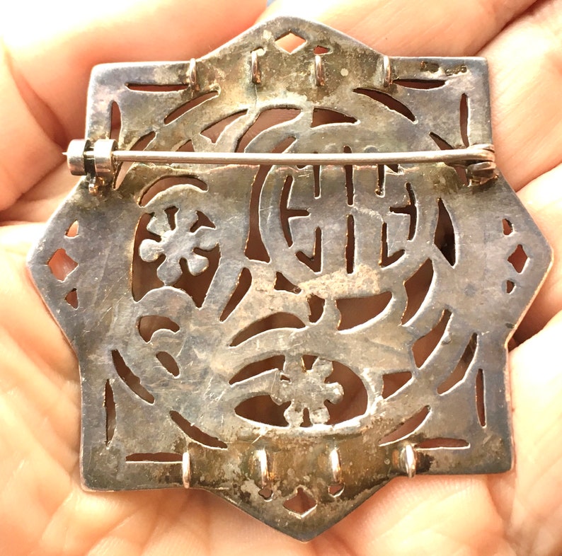 May include: Silver filigree brooch with a floral design and the number "925" stamped on the back.