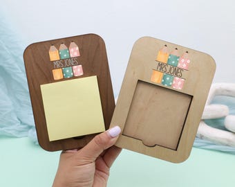 May include: Two wooden memo holders, one with a dark brown finish and a yellow sticky note pad, the other with a natural wood finish. Both have a pencil and block design with the text "MRS JONES".