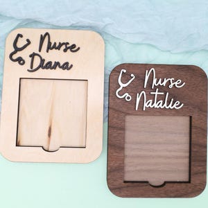 Pu&ograve; includere: Due cornici per foto in legno con un ritaglio per una foto. Le cornici sono realizzate in diversi tipi di legno. Una cornice &egrave; marrone chiaro e l'altra &egrave; marrone scuro. Entrambe le cornici hanno uno stetoscopio e la parola "Infermiera" con un nome sotto. La cornice marrone chiaro dice "Infermiera Diana" e la cornice marrone scuro dice "Infermiera Natalie".