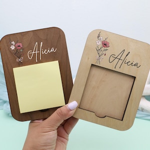 May include: Two wooden memo holders, one dark brown and one light brown, each with the name "Alicia" in script. Floral designs and a yellow sticky note are visible. The light brown holder has a cutout.