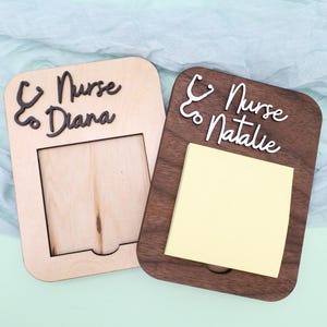 Pu&ograve; includere: Due porta-appunti in legno con un design a stetoscopio e il testo "Nurse to Diana" e "Nurse to Natalie". Un porta-appunti ha un post-it vuoto e l'altro ha uno spazio vuoto per una foto.