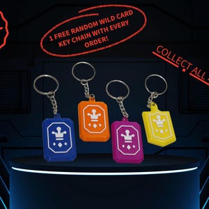 May include: Four keyrings in blue, orange, pink, and yellow, each with a crown design. The image includes the text "COLLECT ALL 4!!", "1 FREE RANDOM WILD CARD KEY CHAIN WITH EVERY ORDER!" and "FREE".