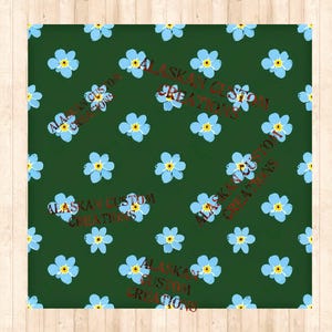Peut inclure: Un motif sans couture composé de fleurs bleues myosotis sur un fond vert foncé. Le motif est répété sur toute l'image. Le texte "Alaskan Custom Creations" est répété en rouge métallique sur toute l'image.