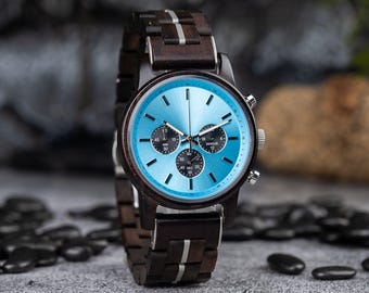 May include: A blue chronograph watch with a black and white wooden band. The watch face has silver hands and markers.