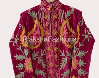 May include: A magenta velvet jacket with intricate floral embroidery in yellow, green, and pink. The jacket features a high collar and is embellished with detailed stitching. The text "LakshaFashions" is visible on the jacket.