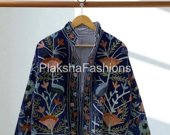 May include: A navy blue jacket with floral embroidery in shades of orange, green, and pink. The jacket has a high collar and a striped lining. The jacket is hanging on a wooden hanger.